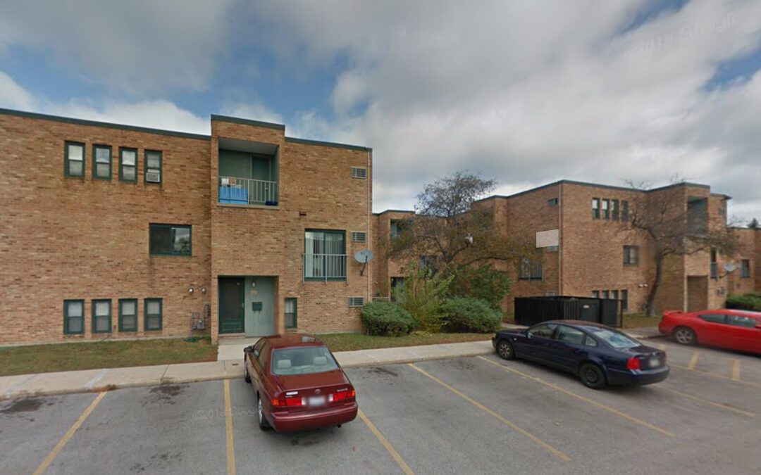 Exterior view of Jackson Park Terrace 3-story building, featuring a parking lot and trees.
